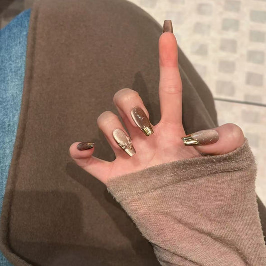 Mocha Gold Foil Tips set of almond-shaped press-on nails featuring a warm taupe-brown base with a smooth, creamy finish